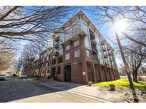 Beautiful low-angle shot of a brick condo building with balconies and a lush lawn on a sunny day at 1101 W 1St St # 124, Charlotte, NC 28202