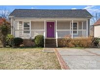 Charming home featuring a covered porch, a purple front door, and nicely maintained landscaping at 114 Glen Rae Sw St, Concord, NC 28025