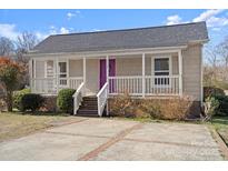 Charming home featuring a covered porch, a purple front door, and nicely maintained landscaping at 114 Glen Rae Sw St, Concord, NC 28025