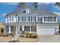 Charming two-story home with white siding, black shutters, a pink front door, and a well-manicured front lawn at 1176 Weir Ct, Fort Mill, SC 29708