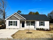 Charming single-story home features a symmetrical design and a well-manicured front yard with a concrete driveway at 1350 Russell St, Rock Hill, SC 29730