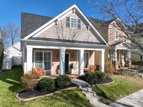 Charming home with a cozy front porch, swing seating, manicured landscaping, and a well-maintained lawn at 16619 Spruell St, Huntersville, NC 28078