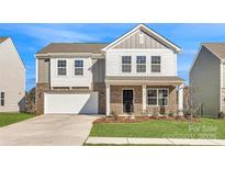 Charming two-story home featuring a brick facade, attached garage, and well-maintained front lawn at 1705 Wooten Way, Bessemer City, NC 28016