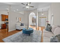 Bright and airy living room featuring hardwood floors, white furniture, and a blue ottoman at 4405 Zee Ct, Monroe, NC 28110