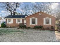 Charming single-story brick home featuring white-trimmed windows and a well-maintained front lawn at 4415 Mapleleaf Ln, Charlotte, NC 28208