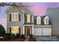 Charming two-story home featuring a two-car garage and a welcoming front entrance with beautiful, manicured landscaping at 10142 Linksland Dr, Huntersville, NC 28078