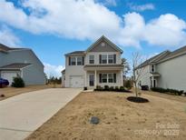 Charming two-story home with landscaped yard and attached garage in a suburban neighborhood at 113 Clove Hitch Dr, Statesville, NC 28677