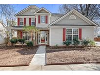 Charming two-story home featuring red shutters, stone accents, and a well-manicured front yard at 13206 Meadowmere Rd, Huntersville, NC 28078