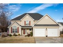 Two-story home with a two-car garage, red shutters, and a well-maintained lawn at 206 Scanlon Rd, Mooresville, NC 28115