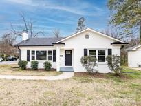 Charming exterior of home featuring a white brick facade, black shutters and door, and manicured landscaping at 2286 Kilborne Dr, Charlotte, NC 28205
