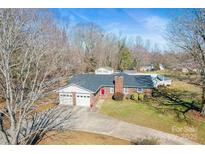 Aerial view of brick home with a two car garage, well maintained yard, and an in ground pool at 2659 Surrey Dr, Lincolnton, NC 28092