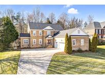 Charming brick home with manicured lawn, long driveway, and attached two-car garage at 305 Chancelot Ln, Fort Mill, SC 29708