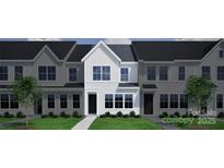 Modern townhome featuring a clean white facade, dark roof, and well-manicured front lawn at 4714 Lakeview Rd, Charlotte, NC 28216
