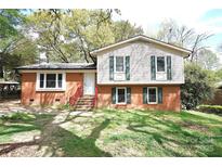Two story home featuring brick facade and upper level vinyl siding and a front yard at 6126 Eagle Peak Dr, Charlotte, NC 28214