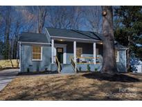 Charming brick home featuring a covered porch, fresh landscaping, and a newly painted exterior at 6813 Elm Forest Dr, Charlotte, NC 28212