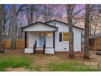 Charming white brick home featuring a blue front door, black trim, and a cozy front porch at 735 Green St, Rock Hill, SC 29730