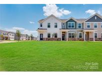 New townhomes feature modern architecture, green lawns, and blue skies in a Gathering-friendly community at 9602 Old Garden Cir, Gastonia, NC 28056