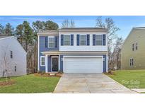 Charming two-story home features a blue and white exterior, attached two-car garage and landscaped yard at 116 Dorian Pl, Troutman, NC 28166