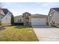 Charming home with a two-car garage, well-maintained lawn, and stone accents at 305 Hemlock Bluff Ct, Denver, NC 28037