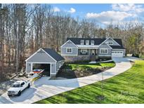 Beautiful two-story home with a three car garage, matching boat garage and lush green yard at 324 Patternote Rd, Mooresville, NC 28117