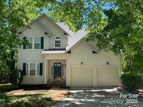 Charming two-story home boasts a two-car garage and a well-maintained front yard with mature trees at 5323 Dewmorn Pl, Charlotte, NC 28269