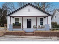Charming home featuring a welcoming front porch with seating and landscaped accents at 720 Holmes St, Salisbury, NC 28144