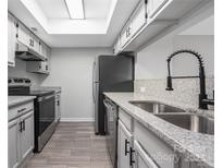 Well-lit kitchen with granite counters, stainless steel appliances, gray cabinets and tile flooring at 8057 Cedar Glen Dr, Charlotte, NC 28212