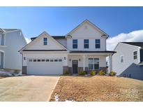 Charming two-story home with white siding, a well-manicured lawn, and an attached two-car garage at 107 Megby Trl, Statesville, NC 28677