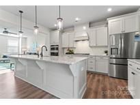 Open-concept kitchen with a large island, stainless steel appliances, and seamless flow to the living room at 1645 Unison Dr, Charlotte, NC 28262