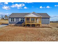 Charming single-story home featuring a covered porch, vinyl siding, and a well-lit exterior at 451 Lookout Dam Rd, Statesville, NC 28625