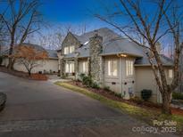 Stately home featuring a stone chimney and accents, complimented by a circular driveway and mature trees at 503 Stuart Rdg, Cramerton, NC 28032