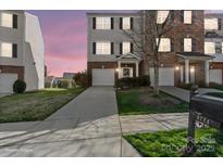 Charming townhome with attached garage, landscaped yard, and inviting entrance at 9724 Walkers Glen Nw Dr, Concord, NC 28027