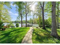 Lush backyard leading to a private boat dock on the serene lake at 141 Baywatch Dr, Mooresville, NC 28117