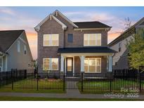 Charming two-story brick home with a fenced front yard and covered porch at 17021 Malone Ln, Mint Hill, NC 28227