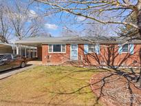 Well-maintained brick ranch-style home featuring blue shutters and a covered carport at 3204 Starrland Dr, Gastonia, NC 28052