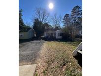 Charming home with a cozy front yard, driveway, and inviting curb appeal under a sunny sky at 3409 Rogers St, Charlotte, NC 28208