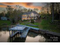 Waterfront home featuring a private dock, meticulous landscaping, and a brick exterior with a balcony overlooking the lake at 4164 54Th Ne Ave, Hickory, NC 28601