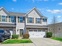Charming two-story townhome with white siding, stone accents, a two-car garage, and well-manicured landscaping at 7441 White Elm Ln, Charlotte, NC 28273