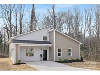 Charming single Gathering home with light grey and beige vinyl siding, black trim, and welcoming covered entryway at 935 Junius St, Gastonia, NC 28052