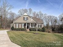 Charming home featuring a well-manicured lawn, mature trees, and classic architectural details at 10000 Dressage Ln, Midland, NC 28107