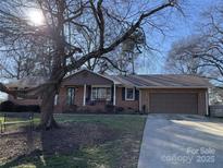 Charming brick home featuring a well-manicured lawn and attached garage at 102 General Bragg St, Stanley, NC 28164