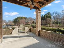 This covered patio features brick columns, a palm ceiling fan, and a beautiful view of the neighborhood at 103 Pier 33 Dr # 207, Mooresville, NC 28117