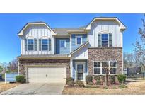 Charming two-story home with stone accents, a two-car garage, and manicured landscaping at 11206 Grenfell Ave, Huntersville, NC 28078