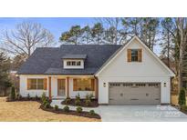 Charming home featuring white siding, stone accents, shutters, and a well-manicured lawn at 153 Kennel Rd, Stanfield, NC 28163