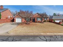 Charming single-story brick home features a well-manicured front yard and attached garage at 1910 Connemara Ct, Gastonia, NC 28054