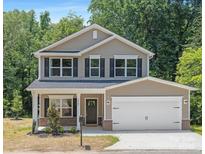 Inviting two-story home with a two-car garage and landscaped front yard surrounded by lush green trees at 222 Ventner Ct, Charlotte, NC 28214