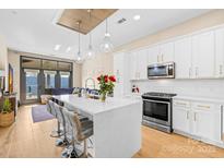 Beautiful kitchen boasts a large island with quartz countertops, stainless steel appliances, and modern pendant lighting at 2401 Euclid Ave # 306, Charlotte, NC 28203
