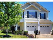 Charming two-story home with a well-manicured lawn, mature tree, and two-car garage at 249 Sand Paver Way, Fort Mill, SC 29708