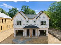 New construction home featuring a modern design with an unfinished garage and covered entryways at 507 Bowman Rd, Charlotte, NC 28217