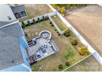 Aerial view of a backyard featuring a custom patio with fire pit and manicured lawn at 634 Gants Rd, York, SC 29745